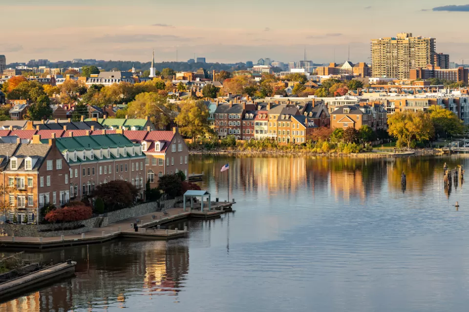 View of Alexandria, Virginia with brick three-story townhomes on Potomac River bank.